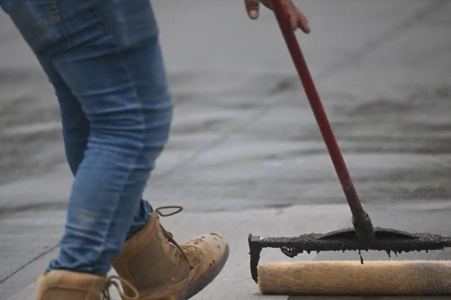 A sealer being rolled onto a hard surface, the treatment resin bound driveways in Rochdale do not require
