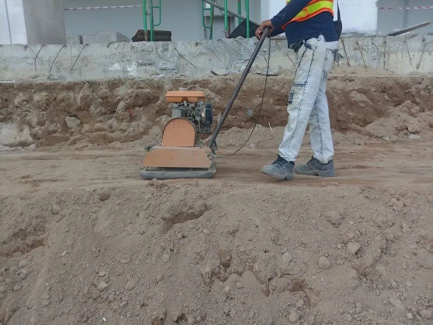 A plate compactor being used to consolidate a driveway sub-base layer