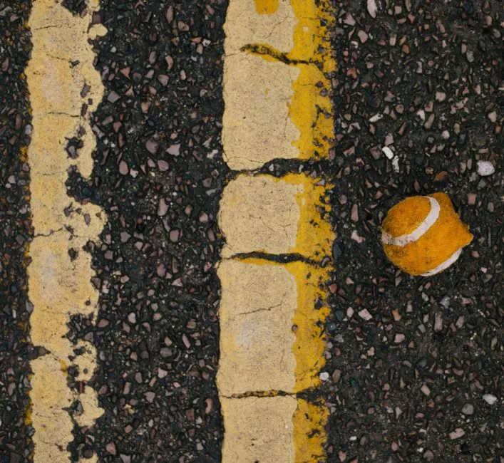 A cracked and worn old tarmac driveway