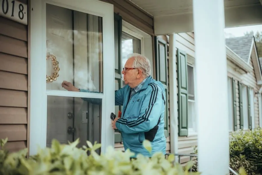 Someone knocking at a suburban front door, the doorstep sealing pitch Rochdale homeowners are offered each spring