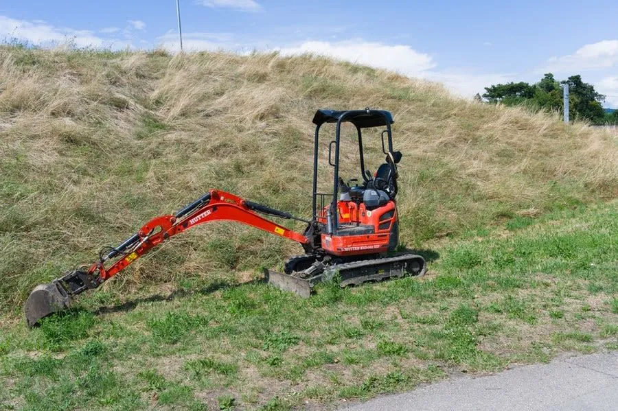 A mini excavator parked on grass ready for groundwork