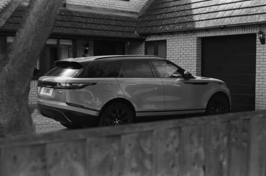 A car parked on a driveway behind a dropped kerb