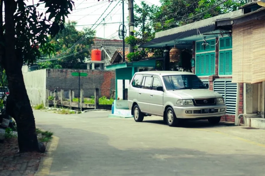 An electric car parked on a driveway outside a home