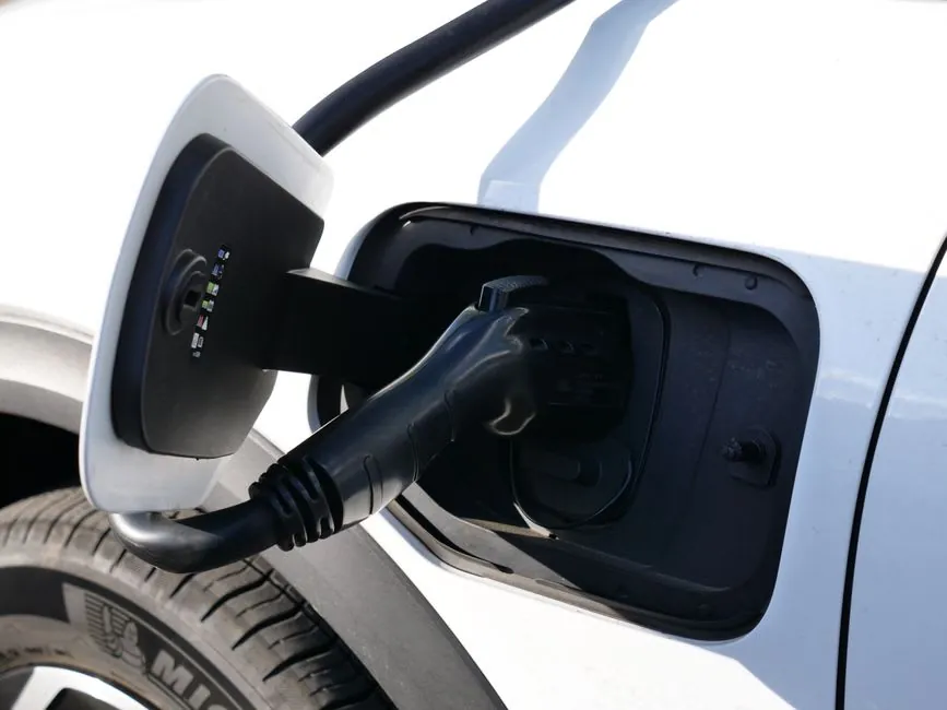 A charging cable running to an electric car on a drive