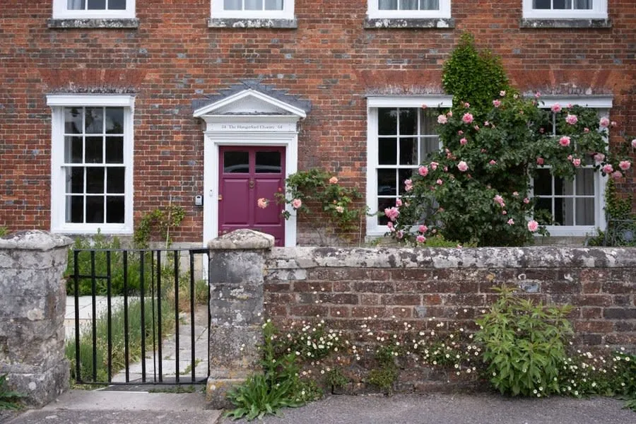The brick frontage and low garden wall of a traditional English house