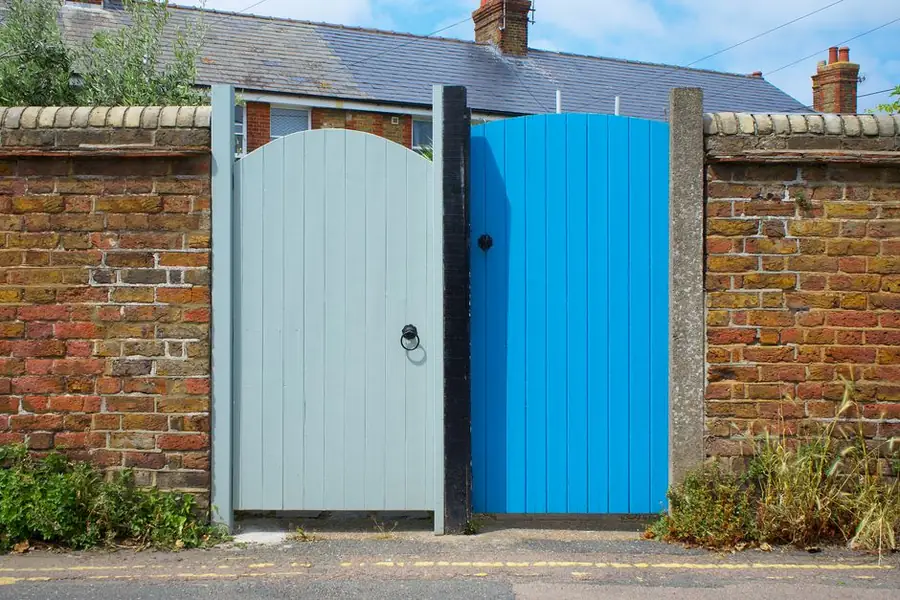 A gate set into a boundary wall at the front of a house