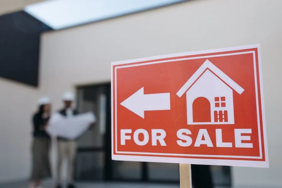 A for-sale sign outside a home with a driveway