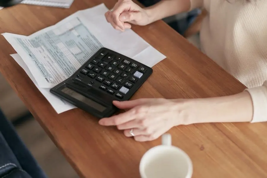 Calculator and paperwork on a desk, working out driveway cost per year across a rental holding period