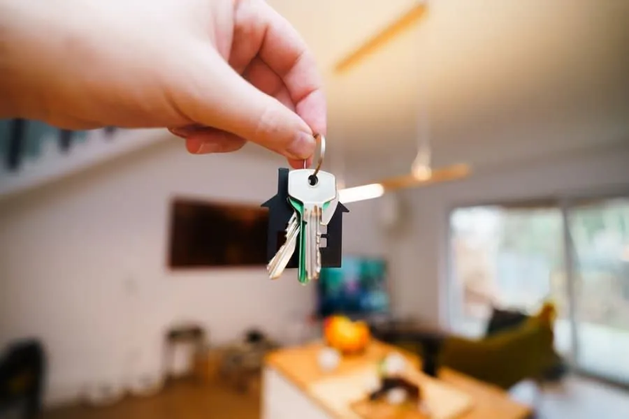 House keys held in a doorway, representing the handover point where a Rochdale landlord's repairs list begins