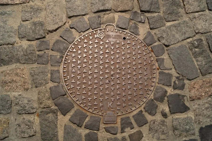 A round inspection cover set flush into a paved surface