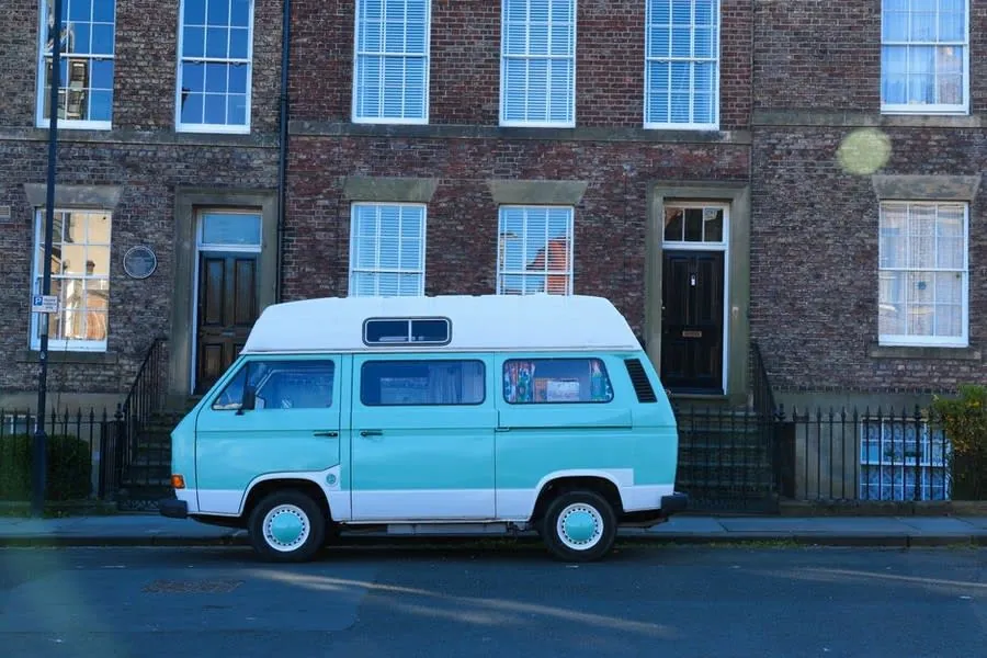 An installer's van parked outside a brick terraced house in a Rochdale street