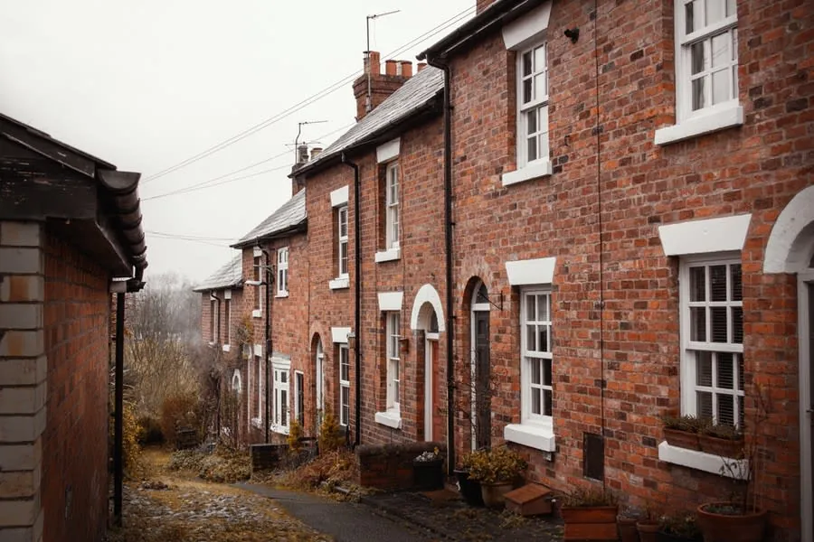 A row of brick terraced houses on a Rochdale street under overcast skies