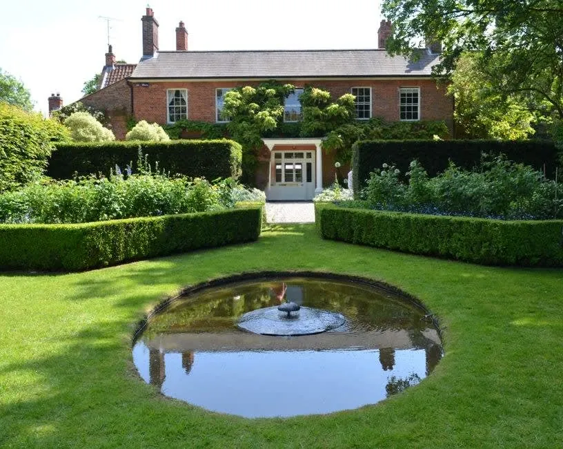 The lawn and planting of a front garden at a traditional brick house