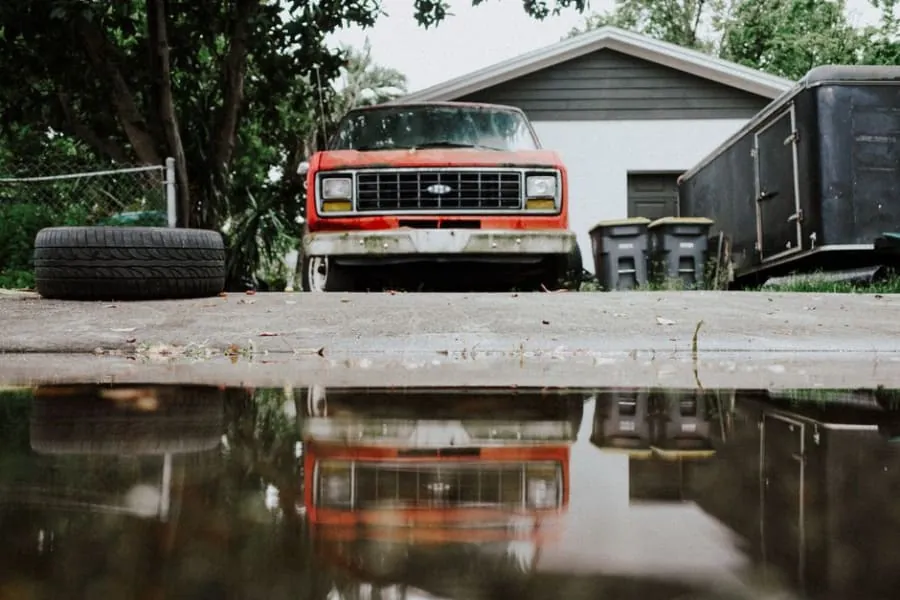Standing water pooling on an old driveway