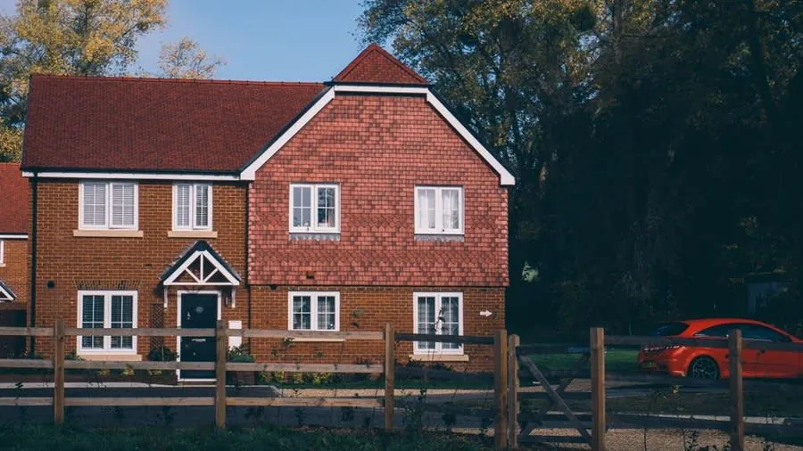 A brick-fronted British home with an off-street parking area at the front