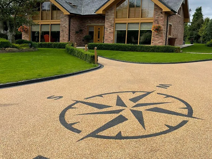 A black compass shape in a gold resin driveway.