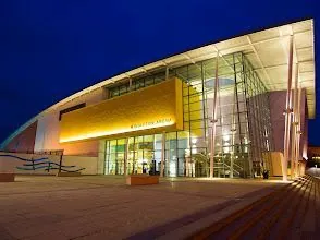 A large building with a lot of windows is lit up at night.