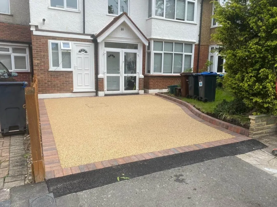 A resin driveway with red and brown blocks as the edge.