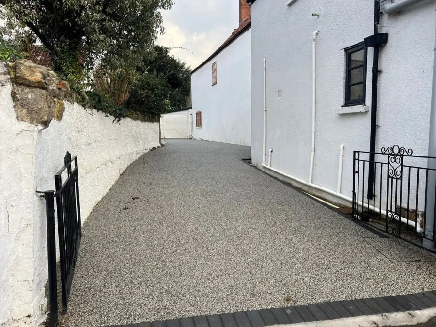 A gravel driveway leading to a white building