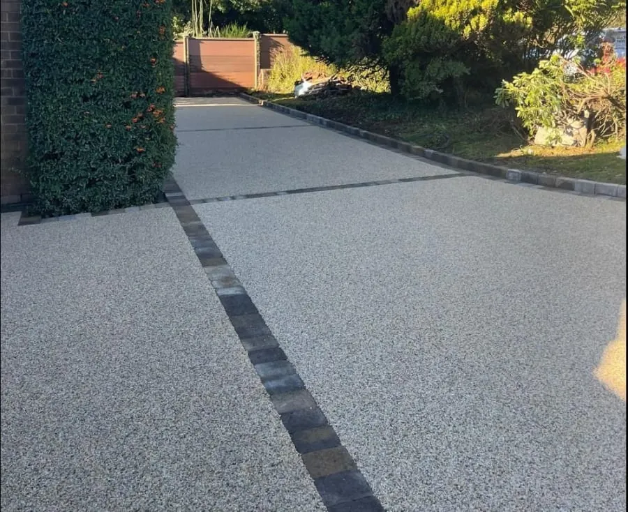 A sloping resin bound driveway running up to the wall of a Rochdale house