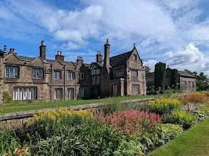 A large stone building with a garden in front of it.